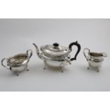 AN EDWARDIAN THREE-PIECE TEA SET with oval bodies, gadroon & shell borders and four feet, the
