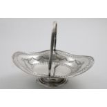 A GEORGE VI SWING-HANDLED FRUIT BASKET of shaped oval outline with pierced and stamped borders,