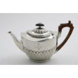 A LATE VICTORIAN PART-FLUTED TEA POT oval, with an angular wooden handle, crested & initialled "R"