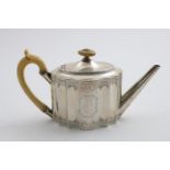 A GEORGE III SHAPED OVAL TEA POT with a serpentine outline, engraved decoration and an ivory