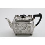A VICTORIAN RECTANGULAR TEA POT with panelled sides, button feet and incurved corners, engraved