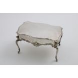 AN EDWARDIAN NOVELTY DRESSING TABLE BOX in the form of a table with a serpentine outline, decorative