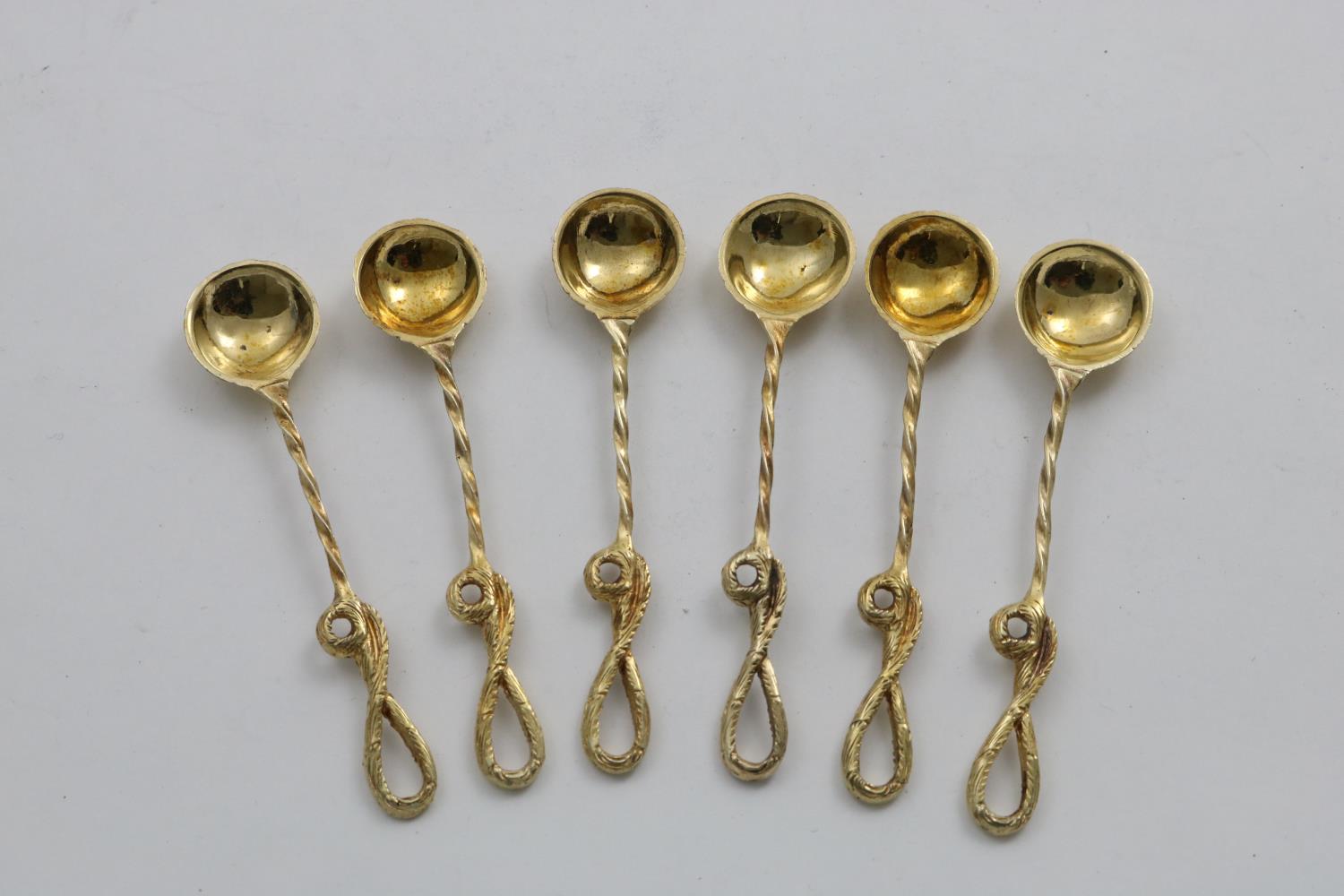 A SET OF SIX VICTORIAN SILVERGILT SALT SPOONS with chased whip ends, shell bowls and twist stems, by