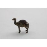 AN EDWARDIAN NOVELTY PINCUSHION in the form of a standing camel, stuffed and loaded, by Adie and