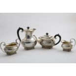 A GEORGE V FOUR-PIECE TEA SERVICE with rounded rectangular bodies, winged paw feet and borders of