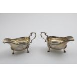 A PAIR OF GEORGE V SAUCE BOATS on three fluted legs with stepped hoof feet and gadrooned rims, by