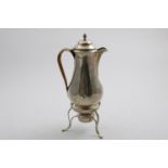 A LATE VICTORIAN HOT WATER JUG on a three legged stand with burner, the baluster vessel with a
