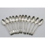 A SET OF TWELVE GEORGE III TEA SPOONS with shoulders, feather-edging and a twist pattern up the