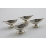 A SET OF FOUR GEORGE III SCOTTISH SALTS boat-shaped with navette-shaped pedestal bases and scroll