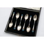 A CASED SET OF SIX GEORGE V HANDMADE COFFEE SPOONS with a hammered finish, the terminals with an