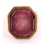 A GOLD SIGNET RING the octagonal intaglio stone of pink tourmaline, engraved with the Royal Arms &