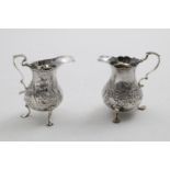 A GEORGE III BALUSTER CREAM JUG on three legs, with a punch-beaded rim and a vacant cartouche, by