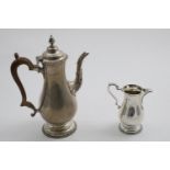 AN ELIZABETH II COFFEE POT in the George III style with gadrooned borders and baluster body,