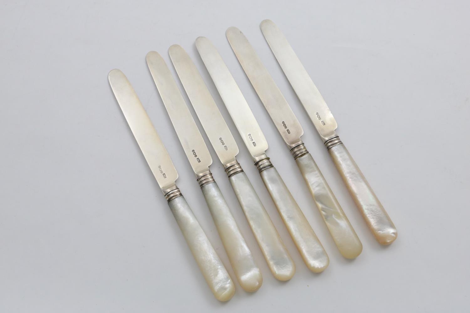 A SET OF SIX GEORGE III / IV DESSERT KNIVES with mother of pearl handles and reeded ferrules, by