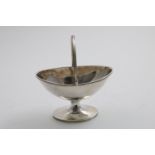 A GEORGE III SWING-HANDLED SUGAR BASKET on an oval pedestal foot, with reed borders, by John Robins,