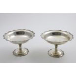 A PAIR OF GEORGE V PEDESTAL BONBON DISHES with decorative wavy rims, initialled "T" in the