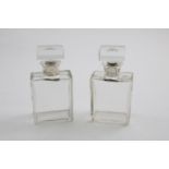 A PAIR OF GEORGE V MOUNTED GLASS BOTTLES of rectangular form with square stoppers, by Hollings and