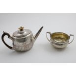 A GEORGE III ENGRAVED OVAL TEA POT with a part-fluted body and cover and a straight, tapering spout,