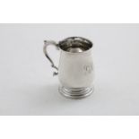 A GEORGE III SMALL BALUSTER MUG with a leaf-capped scroll handle, and a spreading circular foot,