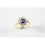 A SAPPHIRE AND DIAMOND CLUSTER RING the oval-shaped sapphire is set within a surround of ten