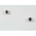 A PAIR OF SAPPHIRE AND DIAMOND CLUSTER STUD EARRINGS each earring is set with an oval-shaped
