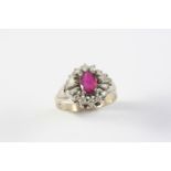 A RUBY AND DIAMOND CLUSTER RING the oval-shaped ruby is set within a surround of circular-cut and