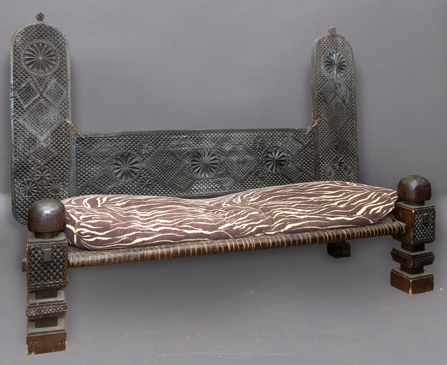 LARGE CARVED AFRICAN SETTLE of unusually large size, the back with two upright sections and panel