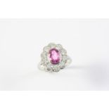 A PINK SAPPHIRE AND DIAMOND CLUSTER RING the oval-shaped pink sapphire is set within a surround of