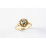 A CHRYSOBERYL CAT'S EYE AND DIAMOND CLUSTER RING the circular chrysoberyl is set within a surround