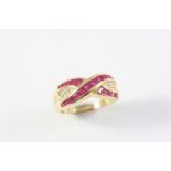 A RUBY AND DIAMOND CROSS-OVER RING set with calibre-cut rubies and circular-cut diamonds, in