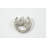 A DIAMOND SET HORSE'S HEAD AND HORSESHOE BROOCH pave set with circular-cut diamonds, with emerald