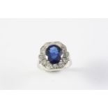 A SAPPHIRE AND DIAMOND CLUSTER RING the oval-shaped sapphire is set within a surround of circular-