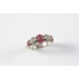 A RUBY AND DIAMOND RING formed with five alternate sections of circular-cut rubies and diamonds,