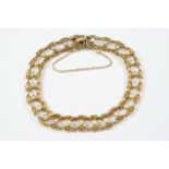 A GOLD AND PEARL SET FANCY LINK BRACELET mounted with small half pearls, with concealed clasp,
