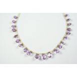 AN AMETHYST AND PEARL NECKLET the graduated oval-shaped amethyst drops are suspended from a row of