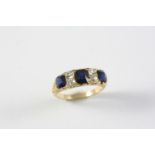 A SAPPHIRE AND DIAMOND RING the three graduated oval-shaped sapphires are set with four cushion-