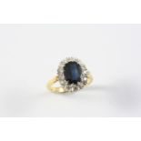 A SAPPHIRE AND DIAMOND CLUSTER RING the oval-shaped sapphire is set within a surround of circular-