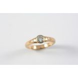 A DIAMOND SOLITAIRE RING the collet set circular-cut diamond is mounted with two small diamonds on