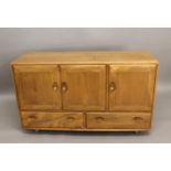 ERCOL SIDEBOARD a light elm sideboard with a two door cupboard with shelf, and a single cupboard
