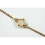 A LADY'S 9CT GOLD WRISTWATCH BY BENSON, LONDON the signed circular dial with Arabic numerals, on a