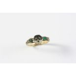 AN 18TH CENTURY ENAMEL, DIAMOND AND EMERALD MEMENTO MORI RING the hinged mask section with black and