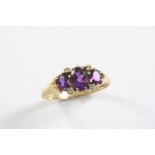 AN AMETHYST AND DIAMOND RING the three graduated oval-shaped amethysts are set with four circular-