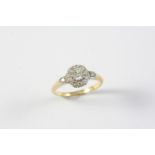 A DIAMOND CLUSTER RING the circular-cut diamond is set within a surround of further circular-cut