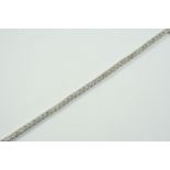A DIAMOND LINE BRACELET formed with fifty six circular-cut diamonds, in 18ct white gold, 18.5cm