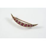 A RUBY AND DIAMOND OPEN CRESCENT BROOCH mounted with graduated oval-shaped rubies and circular-cut
