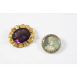 AN AMETHYST AND GOLD BROOCH the oval-shaped amethyst is set within an ornate foliate mount, 4cm