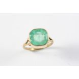 AN EMERALD SINGLE STONE RING the cushion-shaped emerald is mounted in gold. Size Q