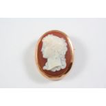 A CARVED HARDSTONE CAMEO BROOCH oval, depicting the head and shoulders of a classical woman, in a