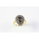 A GARNET AND DIAMOND PEAR-SHAPED CLUSTER RING the pear-shaped cabochon garnet is set within a