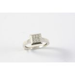 A DIAMOND PLAQUE RING mounted with nine circular-cut diamonds, in 18ct white gold. Size N 1/2